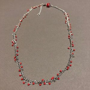 Silver tone necklace with tiny red beads.